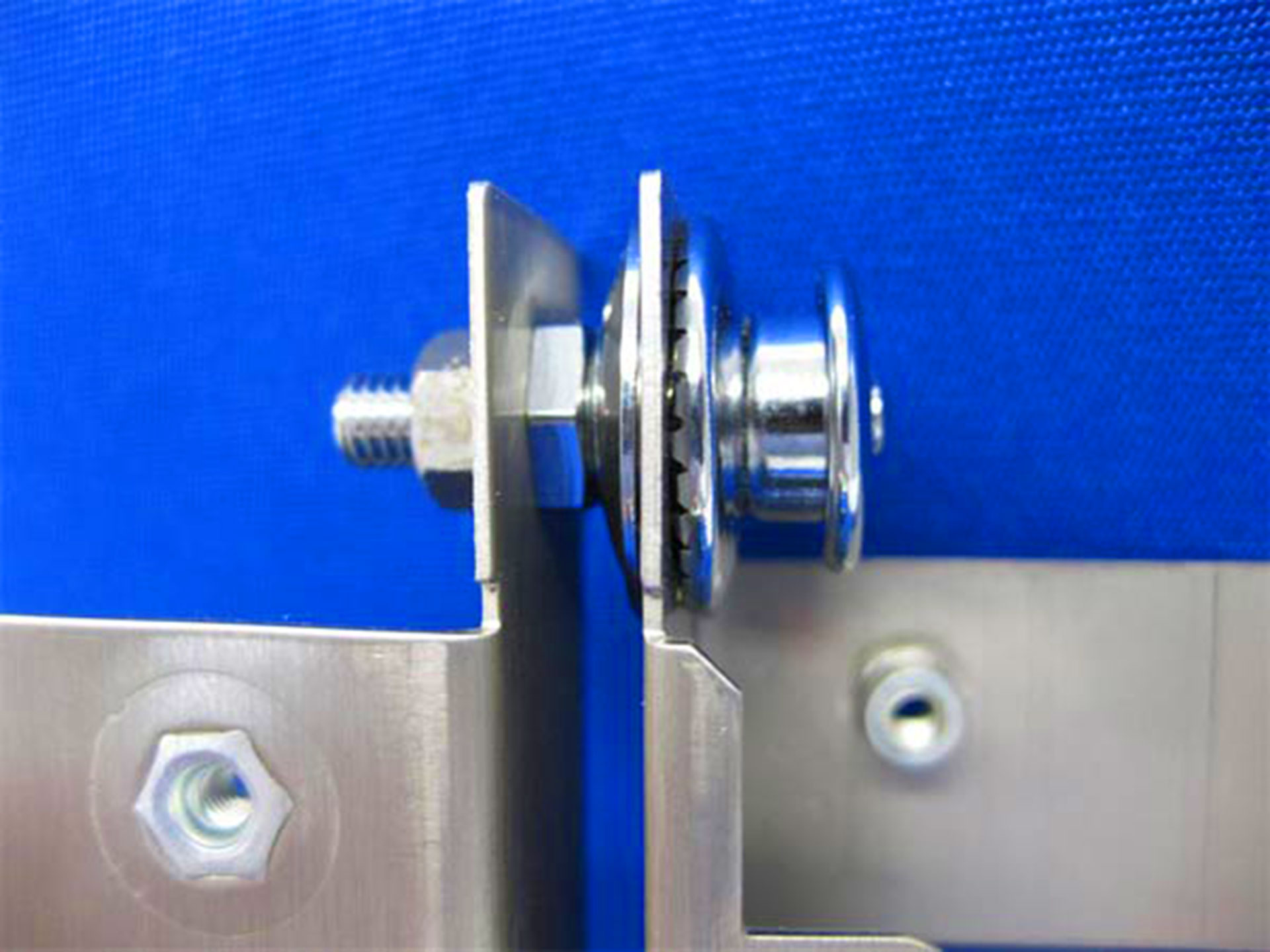 Loxx snap fastener installed through blue canvas and metal bracket hardware